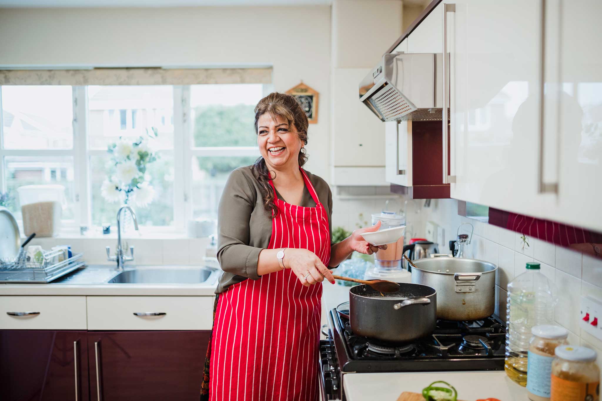 Photo of a smiling woman in the kitchen.