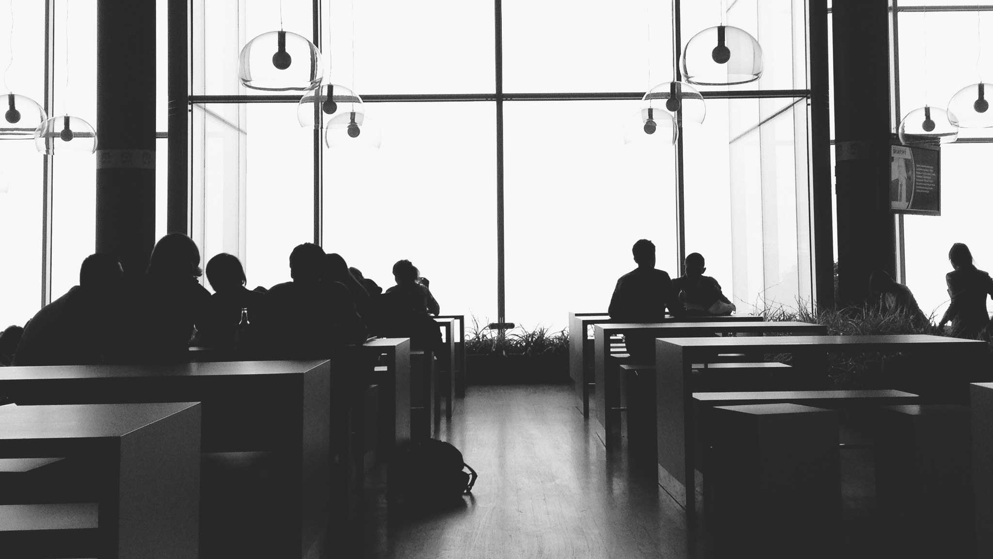 Black and white photo of students in cafeteria.