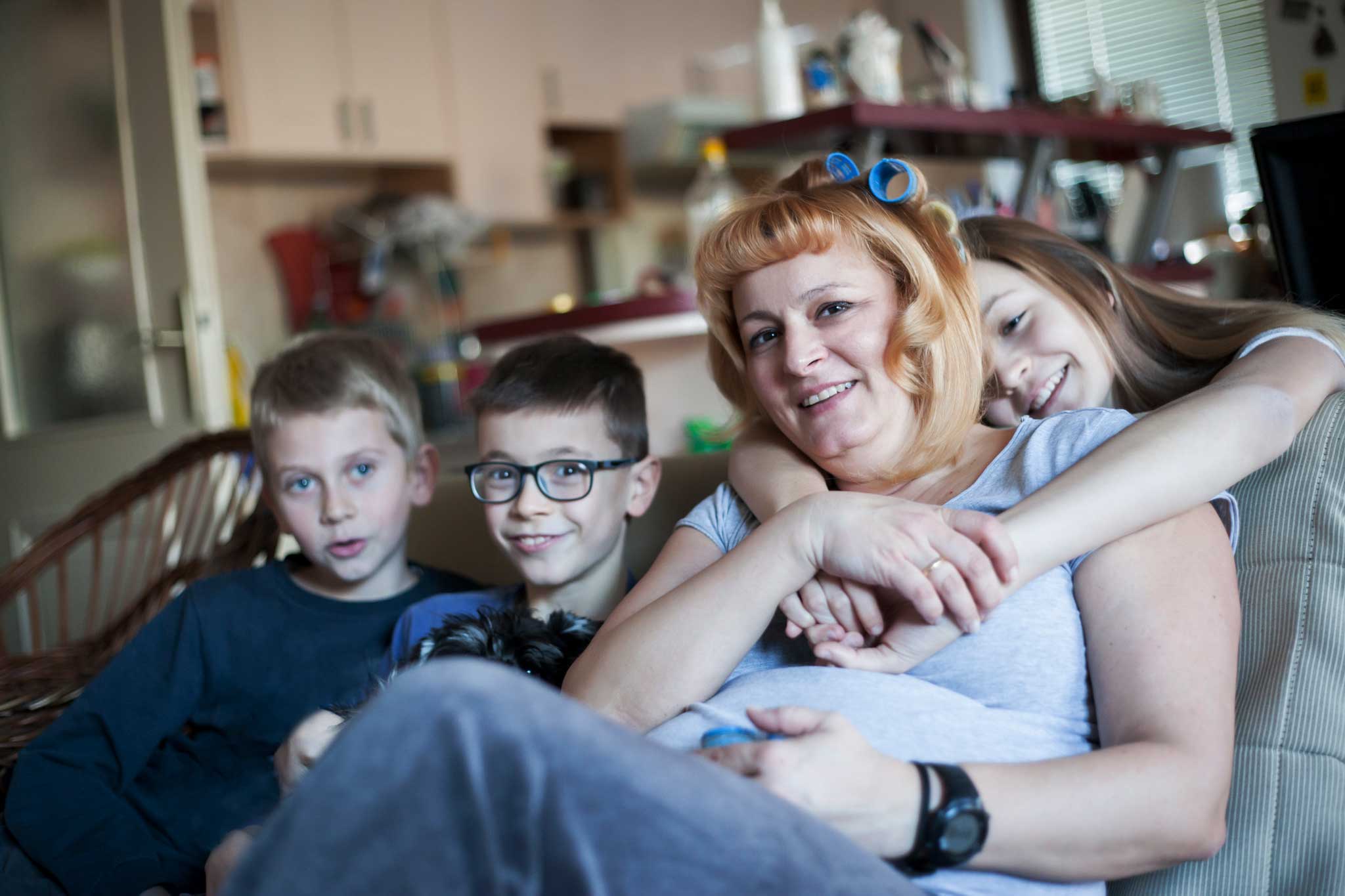 Photo of woman with three children sitting on a sofa.