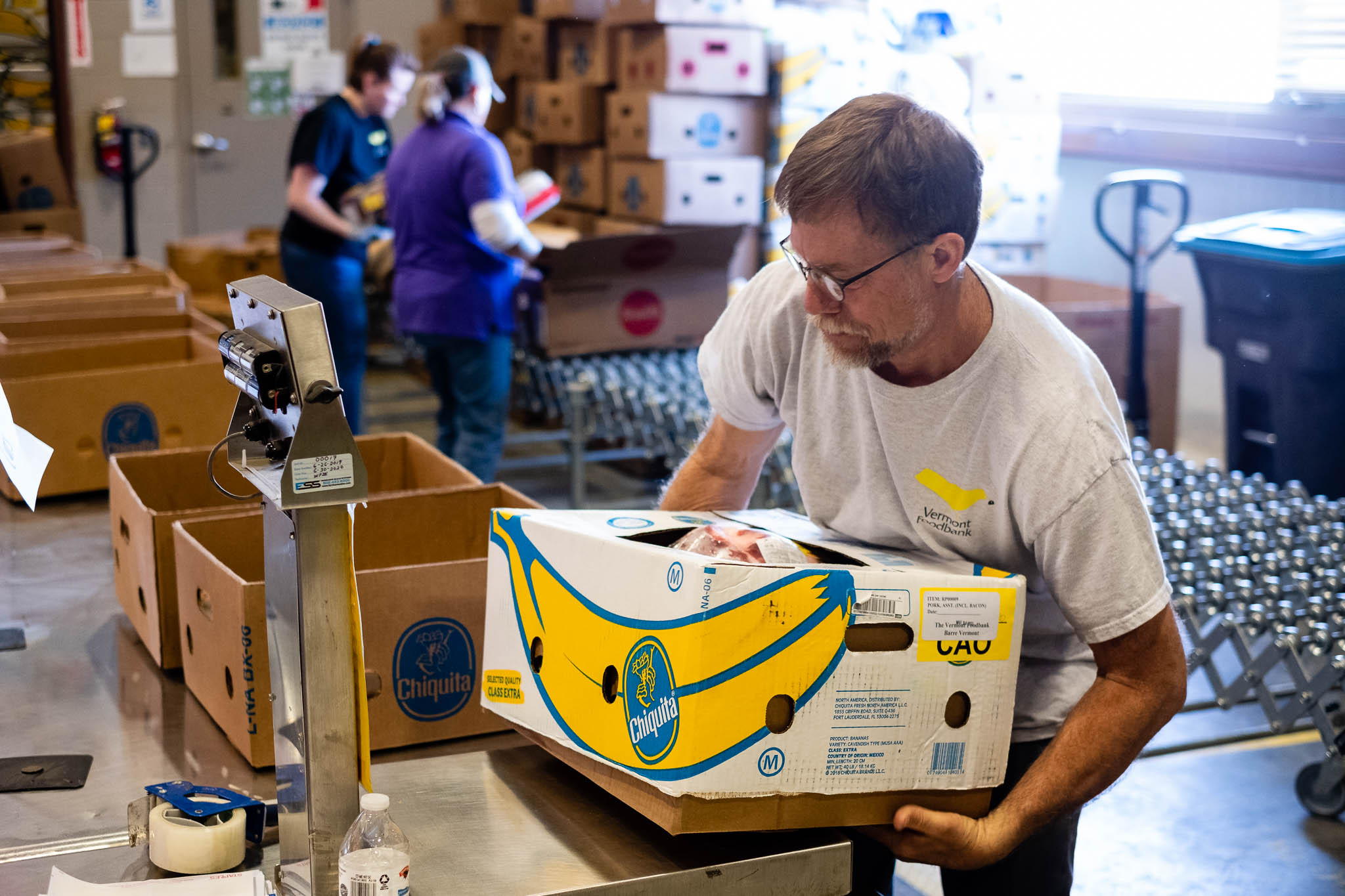 Photo of a Vermont Foodbank worker moving a box of rescue food.