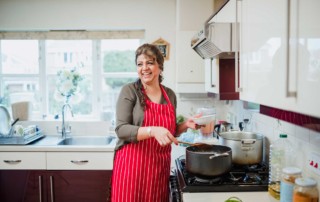 Photo of a smiling woman in the kitchen.