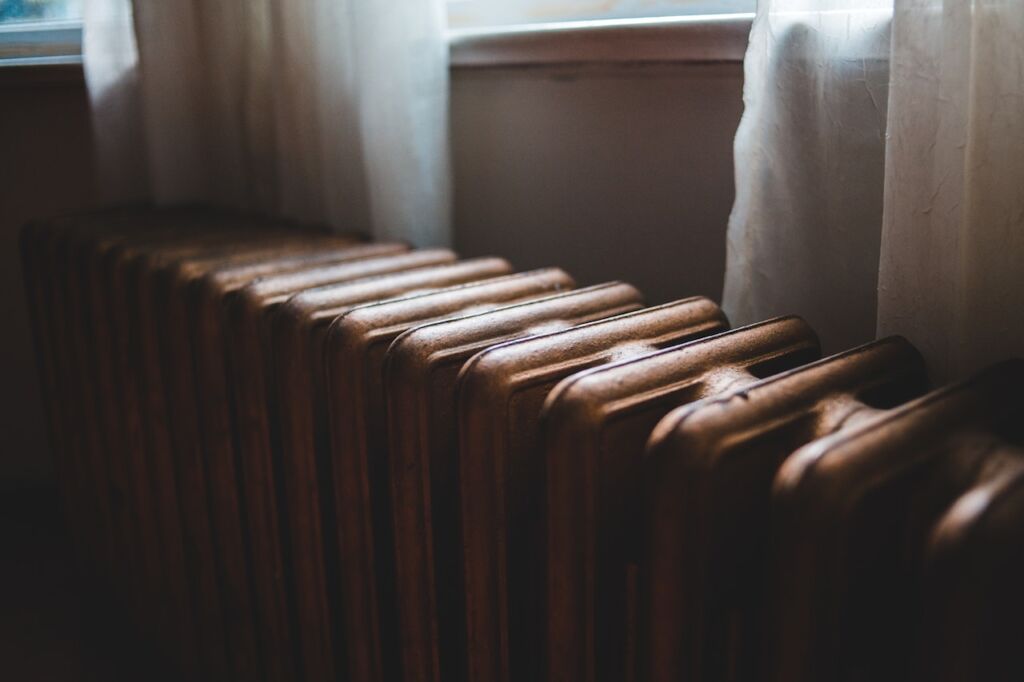 A radiator next to a window.