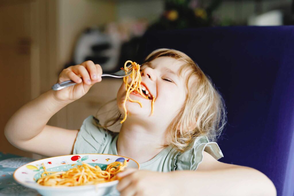 A young child eating spaghetti. 3SquaresVT allows neighbors to boost their grocery budget.