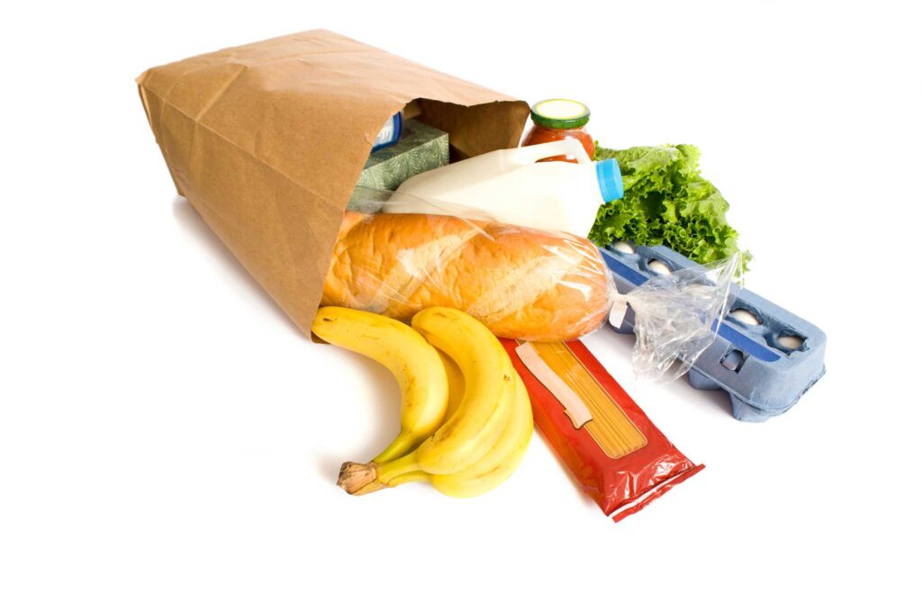 A bag of groceries laying down on a white background.