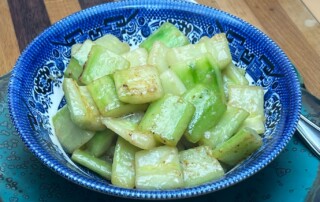 Photo of Miso Glazed Cucumbers in blue bowl.